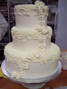 a three tiered white wedding cake with flowers on it