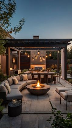 an outdoor living area with couches, tables and fire pit in the middle of it