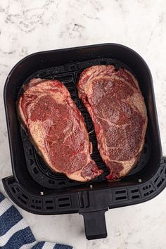 two steaks are being cooked in an air fryer