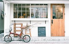 a bicycle is parked in front of a building with a wooden door and window frames