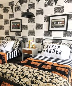 two beds in a room with black and white wallpaper