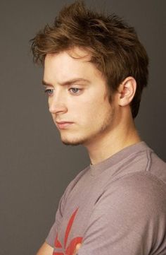 a young man with blue eyes is looking at the camera while wearing a t - shirt