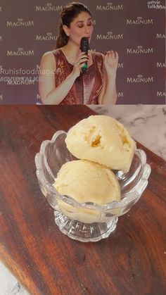 two scoops of ice cream in a glass bowl on a wooden table next to a sign