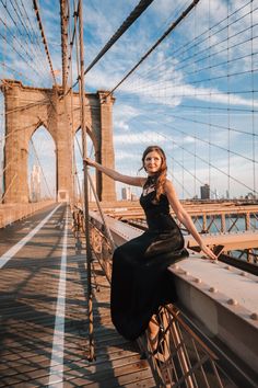 a beautiful woman posing on the side of a bridge