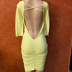 a mannequin wearing a yellow dress with open back