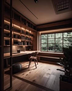 an empty room with wooden shelves and a desk in front of a large window that looks out onto the woods