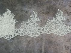 two white lace garters sitting on top of a cement floor