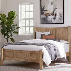 a bed sitting in a bedroom next to a potted plant