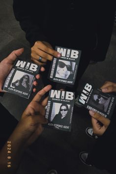 four people holding up small black and white photos with the words nib on them