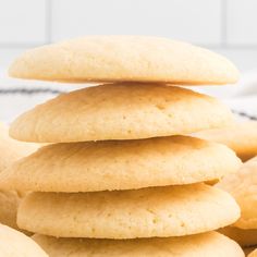 a stack of sugar cookies sitting on top of a white countertop next to other cookies