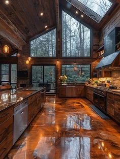 a large kitchen with wooden walls and flooring is lit by lights from the windows