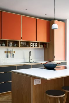 a kitchen with orange cabinets and white counter tops