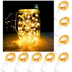 some lights are in a glass jar on the table and one is lit up with gold wire