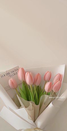 a bouquet of pink tulips wrapped in white paper