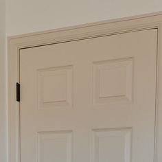 a white door with three square panels on it