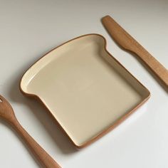 two wooden utensils and a plate on a table