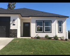 a white house with black garage doors and windows