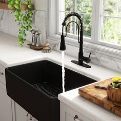 a kitchen sink with a black faucet running water