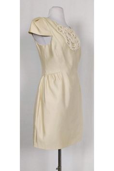 Sophisticated party dress in a rich cream color. A flirty low back, cap sleeves and a beaded design on the front make this dress a stand out garment. Style it with accessories in a bold color for a contrasting touch. Size 6 Silk & cotton blend Rounded neckline Cap sleeves Concealed back zipper Fully lined Beaded design on front Rounded low back Above knee Bust 33" Waist 30" Shoulder to hem 32.25" Feminine Fitted Cap Sleeve Dress, Cream Fitted Dress For Evening, Elegant Lined Beige Dress, Elegant White Cap Sleeve Dress, Cream Short Sleeve Party Dress, Spring Cap Sleeve Cocktail Dress, Fitted Cream Dressy Dress, Cream Fitted Dressy Dress, Chic Cap Sleeve Formal Dress