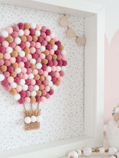 a pink and white balloon with pom - poms hanging from it's side