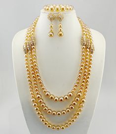 a necklace and earring set with gold beads on a white mannequin head