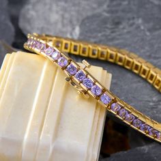 This beautiful line bracelet is accented with forty-nine (49) channel set round modified brilliant natural tanzanites. The bracelet measures 4.8mm wide, 4.6mm thick and has an overall length of 7 inches. The bracelet is finished with a hidden box clasp and figure-eight safety. Luxury Purple Tennis Bracelet, Channel Set, Beautiful Lines, Overalls, Yellow Gold, Yellow, Gold