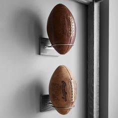 two footballs are hanging on the wall