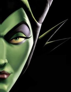 a close up of a person with green makeup and black hair wearing an evil mask