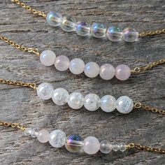 This necklace features a bar focal made with 6mm angel aura quartz round beads: choose from regular clear aura quartz (A), mystic rose quartz (B), crackle aura quartz (C), or mixed (clear, rose, & mixed aura quartz beads), (D). It's on a dainty hypoallergenic chain- choose from stainless steel, gold-plated stainless steel (shown in photos), sterling silver, or gold filled. The closure is a 10mm lobster clasp for the stainless steel options, and a 6mm spring clasp for the sterling and gold filled Gift Iridescent Crystal Necklace With Round Beads, Angel Aura Quartz Necklaces, Rainbow Aura, Angel Aura Quartz, Angel Aura, Quartz Beads, Aura Quartz, Quartz Necklace, Bead Necklace