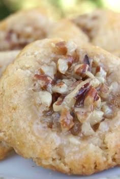 two cookies with nuts on top sitting on a plate