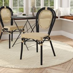 two chairs sitting on top of a rug in front of a dining room table and window