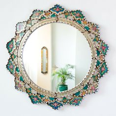 a mirror that is on the wall above a potted plant in front of it