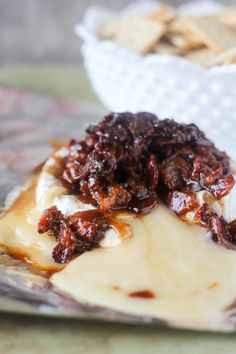 a close up of food on a plate with crackers in the backgroud