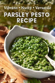 a white bowl filled with pesto on top of a wooden table next to mushrooms