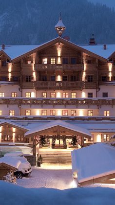 the hotel is lit up at night in the snow