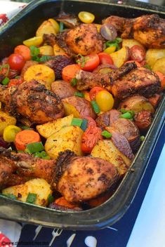 a pan filled with chicken and vegetables on top of a table