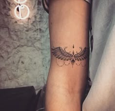 a person with a tattoo on their arm that has an angel wings design on it