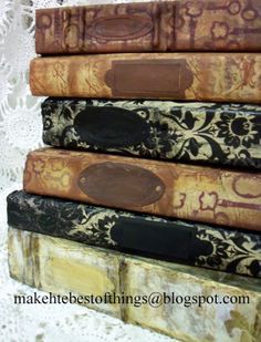 four old books stacked on top of each other in front of a lace doily