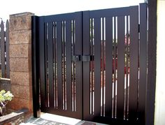 the gate is made of wood and has metal bars on it, along with flowers