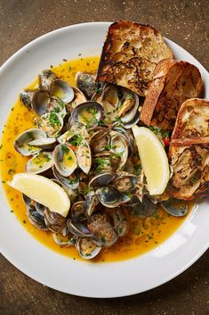 a white plate topped with clams and bread