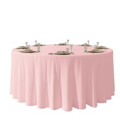 a round table with four silver plates on it and pink cloth draped over the top