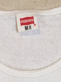 "1970s band tanktop shirt Hanes, cotton, white ribbed The Manhattan Transfer black print Atlantic Records symbol at lower right of image front/back image good vintage condition, light wear light stains, light cracking label size M, see below measures, lying flat, chest-12\" unstretched to 19\" stretched length-26\"" Hanes Tank Top, Manhattan Transfer, 1970s Bands, Atlantic Records, Long Sweaters Cardigan, Levis Denim, Light Stain, Flat Chest, Smock Dress