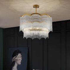 a chandelier hanging from the ceiling in a room with black walls and paintings