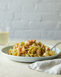 a white bowl filled with food next to a glass of milk