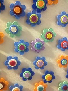 colorful plastic flowers are arranged on a white surface