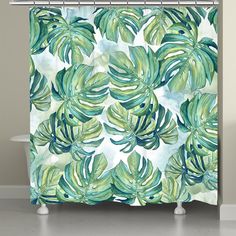 a shower curtain with green and blue leaves on the outside, in front of a bathtub