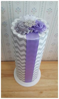 a purple and white striped cake with flowers on top