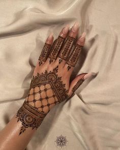 a woman's hand with henna on top of it and the bottom half of her arm