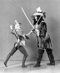 two people dressed in costumes holding swords