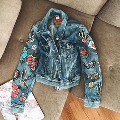 a denim jacket with patches and flowers on it